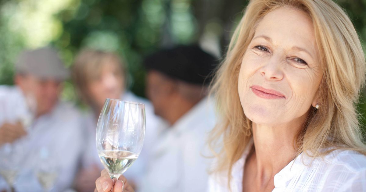 Older woman having wine outdoors